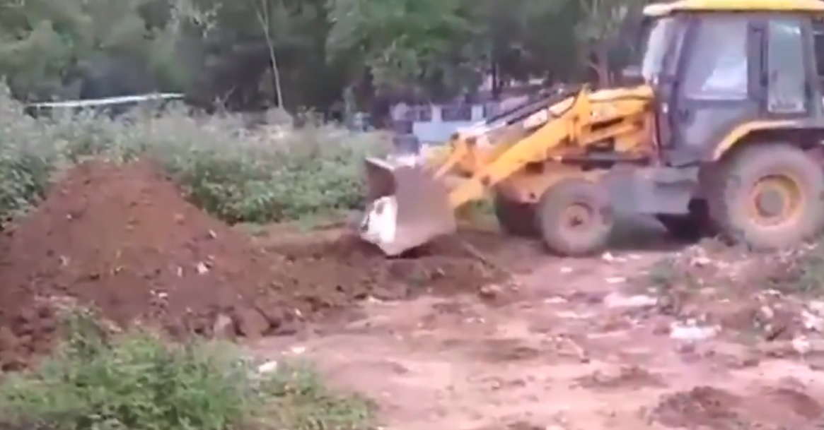 Andhra Covid victim's body dumped into pit by JCB excavator Photo Videograb Twitter