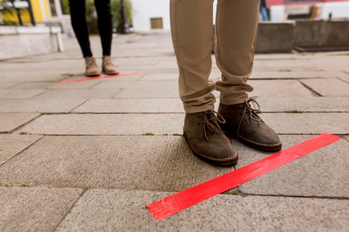 Social Distancing woman-queue-outdoors-with-tape (1)