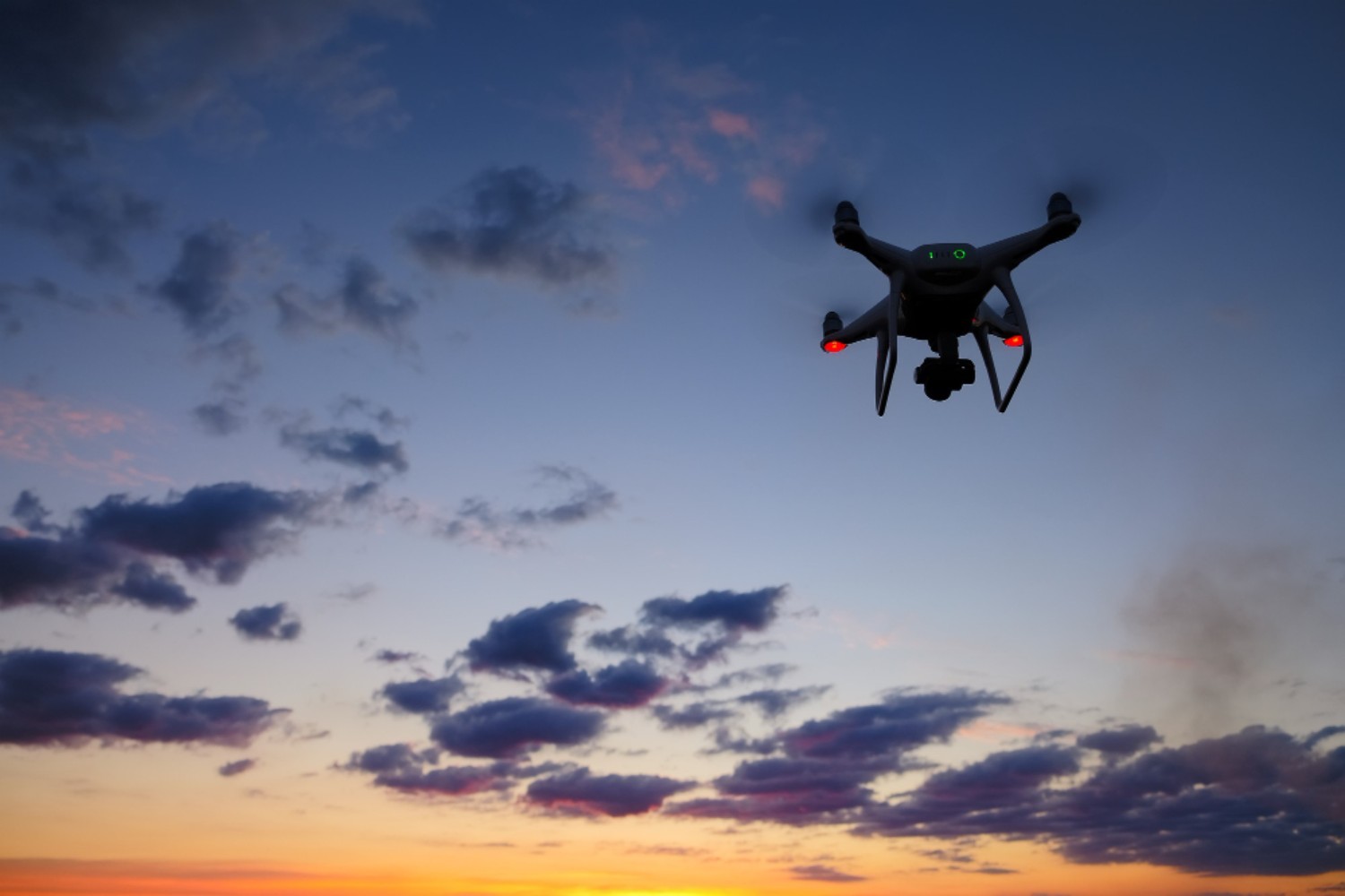 drone-is-flying-field-sunrise-modern-technological-background-silhouette-flying-machine-glowing-red-sunset-sky (1)